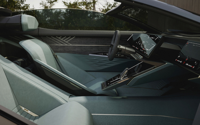 Interior view of a modern, sleek car showcasing a futuristic design with light blue seats and a digital dashboard featuring multiple screens displaying navigation and media controls. The car has a minimalist steering wheel and a central console with touch controls, highlighting the appeal of new cars. The spacious and luxurious cabin design makes it ideal for both new cars and used cars buyers looking for advanced technology and comfort.