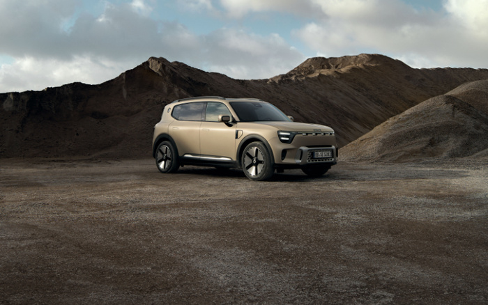 Beige SUV parked on barren land with rocky hills in the background under a cloudy sky, showcasing a modern new car with sleek design and aerodynamic features, suitable for off-road and urban driving, highlighting the appeal of new cars for adventurous and practical users, ideal for used cars buyers seeking durability and style.