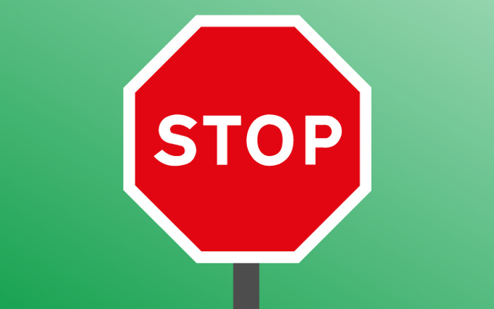 Red octagonal stop sign with white border and the word 'STOP' in bold white letters, set against a green gradient background, symbolising a traffic control for vehicles including used cars and new cars.