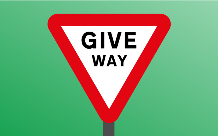 Triangular road sign with a red border and white centre displaying the text 'GIVE WAY' against a green gradient background, relevant for used cars and new cars road safety.