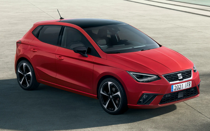 Red Seat hatchback car with black roof, parked on concrete surface, showing front and side view. The car features modern headlights, sporty alloy wheels, and a front grille with the Seat logo. The vehicle has a European license plate reading '2021 1 FR'. Ideal for buyers interested in used cars or new cars in the compact hatchback category.