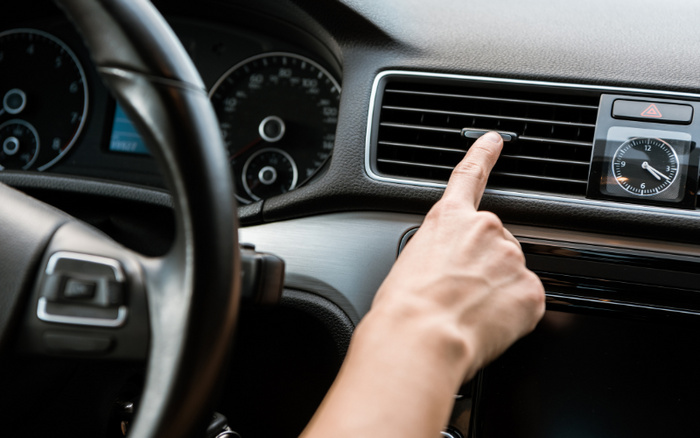 Person adjusting the air conditioning vents inside their vehicle