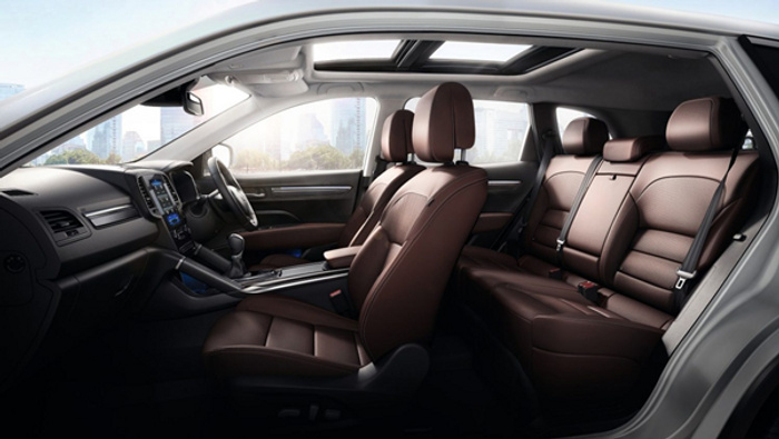 Interior view of a modern car showing brown leather seats, a sunroof, and a sleek dashboard with touchscreen controls, highlighting the spacious and luxurious seating area of this vehicle, suitable for used cars and new cars.