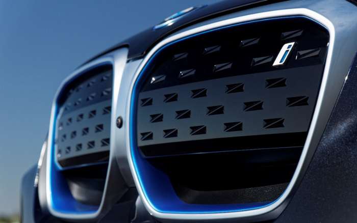Close-up image of the front grille of a blue BMW i series electric car showing the distinctive kidney grille with blue accents and the letter 'i' badge, representing a model from BMW's lineup of new cars, suitable for dealerships offering used cars and new cars.
