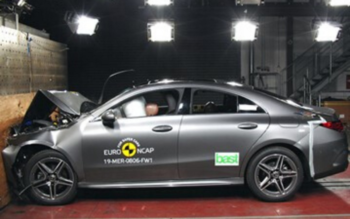 Silver sedan car undergoing crash test in a controlled environment with front impact damage, featuring Euro NCAP logo and test ID 19-MER-0806-FW1 on the front door, and a 'bast' sticker on the rear door, highlighting safety features relevant to used cars and new cars.