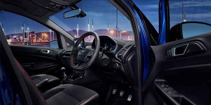 Interior view of a blue new car showing the driver's seat, steering wheel, dashboard with digital display, gear stick, and door with control buttons. The car is parked outdoors with a cityscape and lights visible through the windows, highlighting a modern design suitable for both used cars and new cars markets.