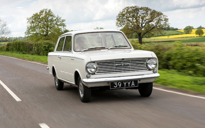 White classic Hillman Imp car with licence plate 39 YYA driving on a rural road with green fields and trees in the background, illustrating vintage used cars and new cars options.
