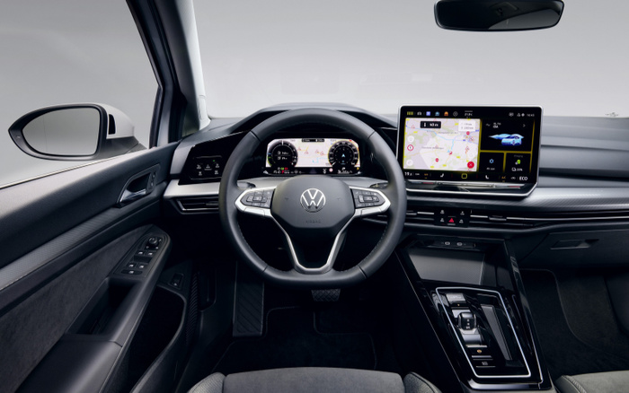 Interior view of a modern Volkswagen car showing the steering wheel with Volkswagen logo, digital dashboard display, and central touchscreen with navigation and car system controls, highlighting features relevant for buyers interested in used cars and new cars.