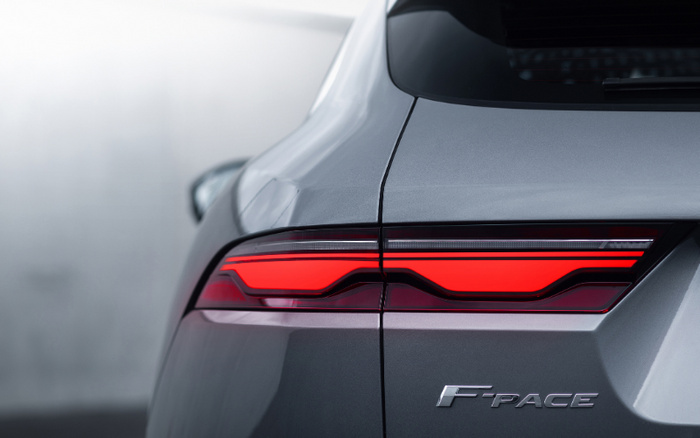 Close-up of the rear light and badge of a silver Jaguar F-PACE, showcasing the distinctive red LED taillight design and the F-PACE nameplate, ideal for used cars and new cars enthusiasts looking for premium SUVs.