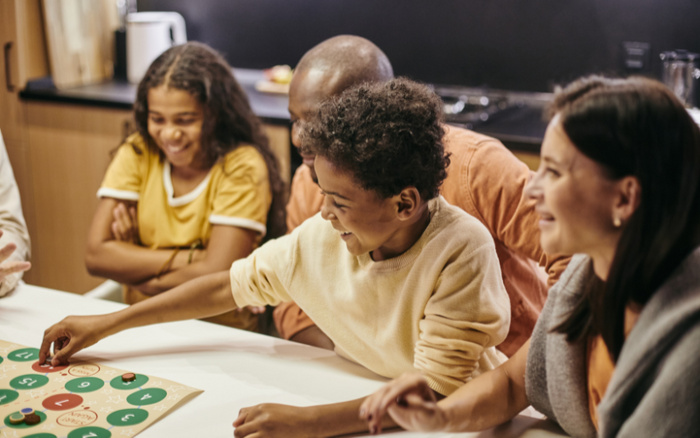 Family seated at a table playing a board game