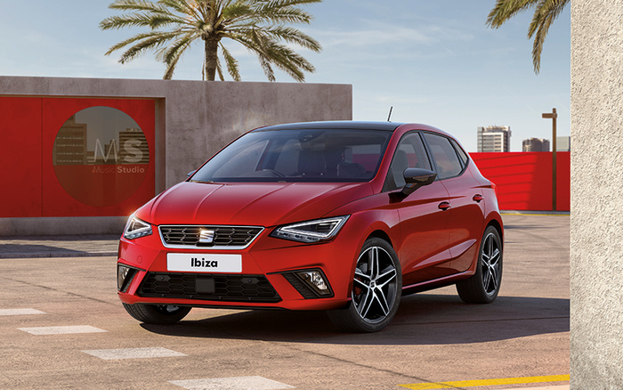 Red SEAT Ibiza car parked outdoors near a building with a sign reading 'M S Music Studio'. The image shows a modern, new car model suitable for used cars and new cars listings, with clear front and side views under natural daylight and palm trees in the background.