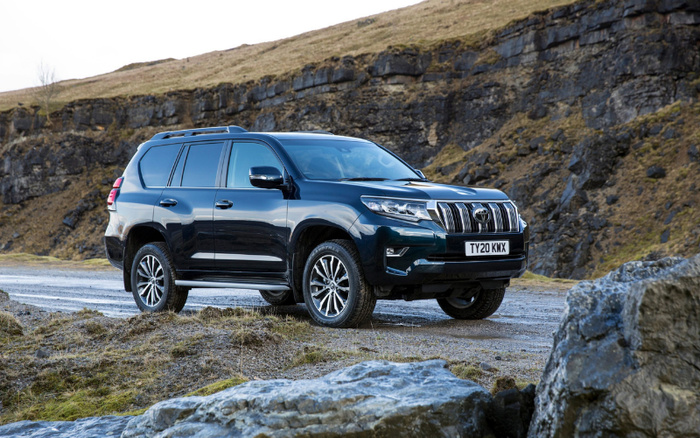 Black Toyota Land Cruiser Prado with registration plate TY20 KMK parked on a gravel road in a rugged, rocky landscape. The vehicle is a used car suitable for off-road driving and adventure, highlighting both used cars and new cars options for buyers seeking durable SUVs.