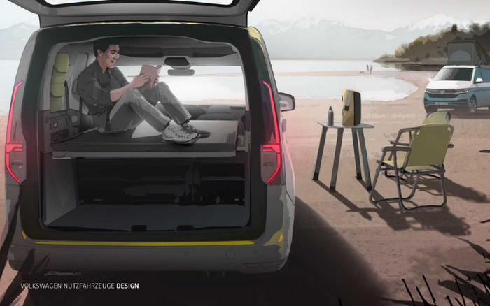 Man sitting comfortably inside the open rear of a Volkswagen vehicle parked on a beach, reading a book. Nearby, there is a small table with a coffee pot and cup, along with a green folding chair. Another Volkswagen vehicle is parked on the sandy shore. The scene showcases spacious vehicle design ideal for outdoor or recreational use. Text at the bottom left reads 'VOLKSWAGEN NUTZFAHRZEUGE DESIGN'. Keywords include used cars and new cars.