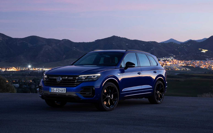 Blue Volkswagen Touareg SUV parked on a road at dusk with illuminated mountains and city lights in the background, featuring license plate BS FQ 449, showcasing a sleek modern design ideal for buyers looking for quality new cars or used cars.