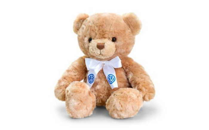 Light brown plush teddy bear with a white ribbon bow around its neck featuring two blue Volkswagen logos, sitting against a white background. The image relates indirectly to used cars and new cars through the Volkswagen branding on the ribbon.