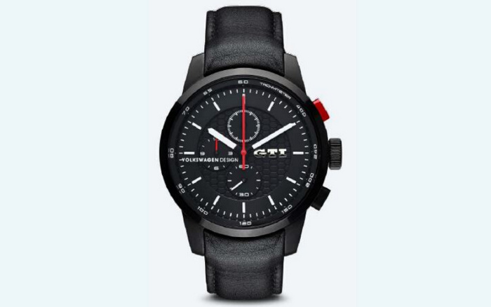 Black Volkswagen Design GTI wristwatch with a black leather strap, featuring a black dial with white hour markers and hands, a red seconds hand, two sub-dials, and the text 'VOLKSWAGEN DESIGN' and 'GTI' on the face. The watch has a sporty design and red and black buttons on the side. Keywords used cars, new cars.