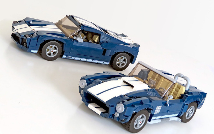 Two detailed blue and white LEGO sports cars displayed on a white background, showcasing models that resemble classic muscle cars, highlighting craftsmanship in new and used cars collections.