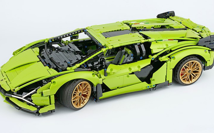 Detailed green LEGO model car with black and gold accents, showcasing an intricate design featuring opening doors, steering wheel, and visible interior components resembling a sports car, representing a creative build rather than used cars or new cars.