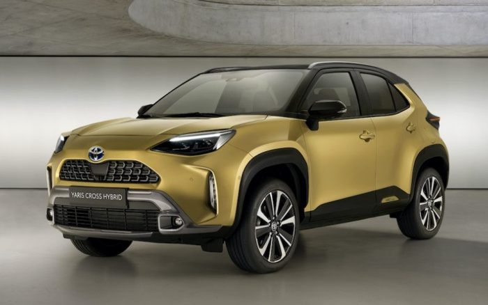 Gold Toyota Yaris Cross Hybrid new car displayed in a modern showroom setting, showcasing front and side view with black roof and alloy wheels, highlighting features suitable for buyers interested in used cars and new cars.