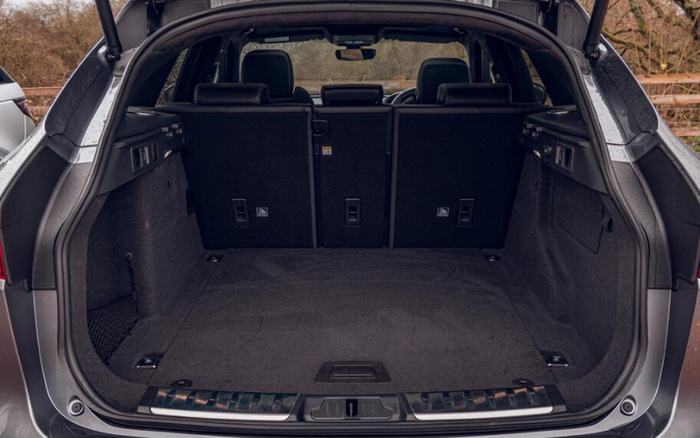 Spacious open boot of a silver car showing clean dark grey carpeted interior, foldable rear seats, side storage compartments, and high-quality finish, ideal for carrying luggage or shopping, suitable for customers interested in used cars or new cars.