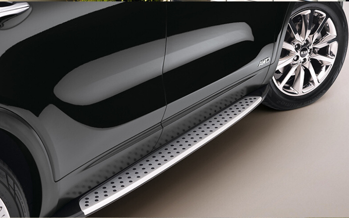 Close-up of a black Kia car showing the side panel with AWD badge, shiny alloy wheel, and a silver metal running board with black rubber dots, showcasing features typical of used cars and new cars.