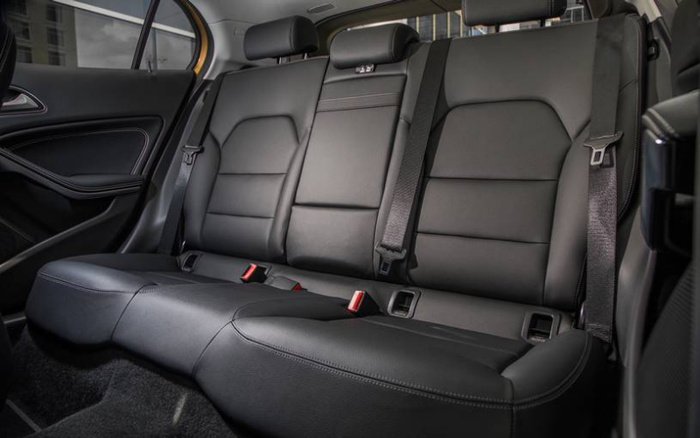 Interior view of a car's rear seats featuring black leather upholstery with three seat belts and red seat belt buckles, highlighting the spacious and sleek design suitable for used cars and new cars.