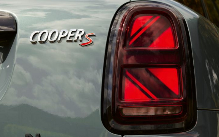 Close-up of the rear section of a Mini Cooper S car showing the chrome 'COOPER S' badge and the distinctive red and black rear tail light on a glossy light green body, suitable for used cars and new cars advertising.
