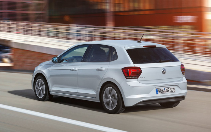 White Volkswagen Polo hatchback driving on a city street with blurred background, licence plate reading WOB NP 300. Image suitable for used cars and new cars advertisements.